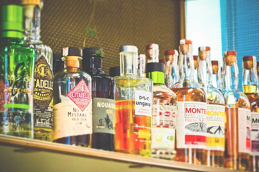 Cocktailbar für Cocktailkurs mit verschiedenen Spirituosen stehend im Regal