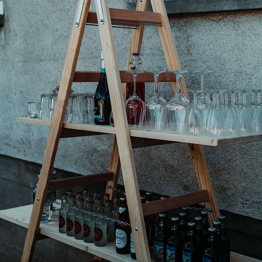 Holzleiter als Bar bestückt mit Gläsern und Spirituosen für Cocktailkurs 